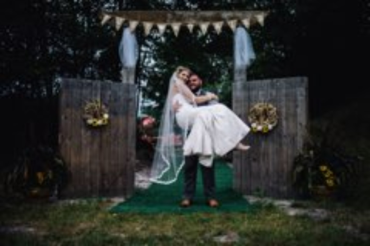 Bride and groom at a rustic outdoor arbor